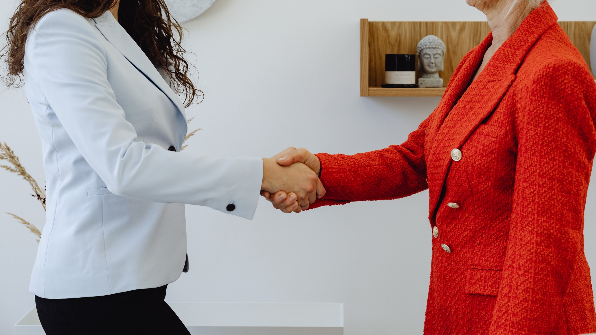 Two business professionals shaking hands after finalizing a business acquisition agreement, representing partnership and trust in small business mergers.