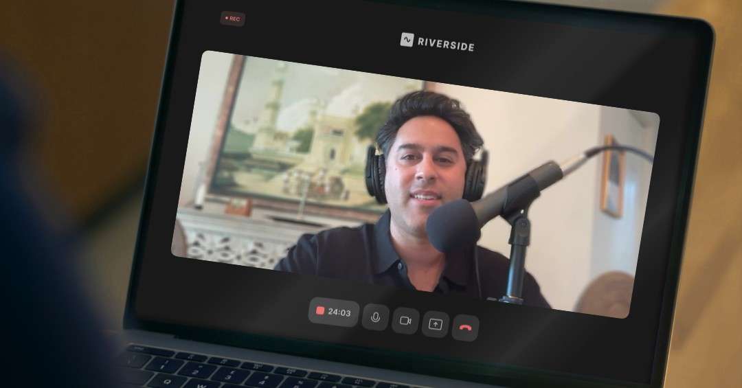 Person wearing headphones speaking into a microphone during a remote podcast recording shown on a laptop screen.