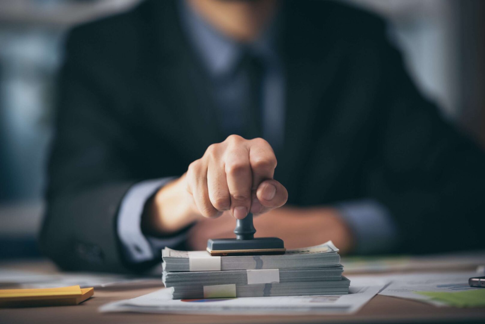 A professional taking notes next to financial charts, a calculator, and a plant growing from a stack of coins, symbolizing business growth and brand value.
