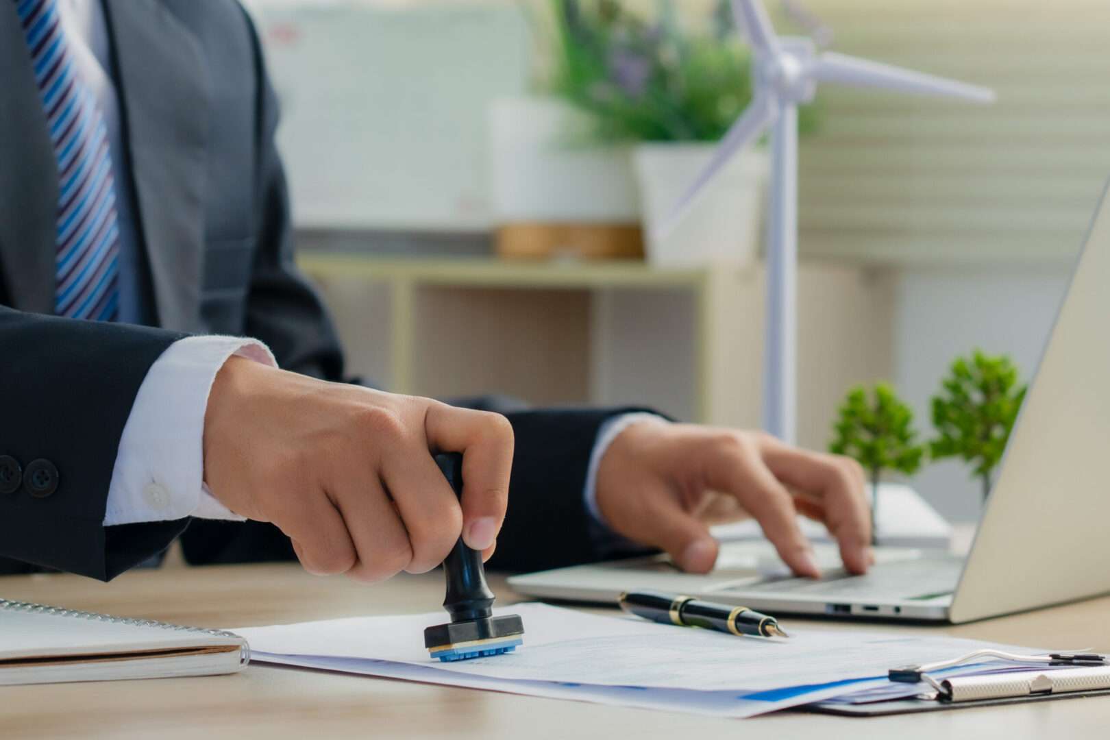 A business professional writing in a notebook next to a calculator, financial charts, and a plant growing from coins, representing LOI financial planning.
