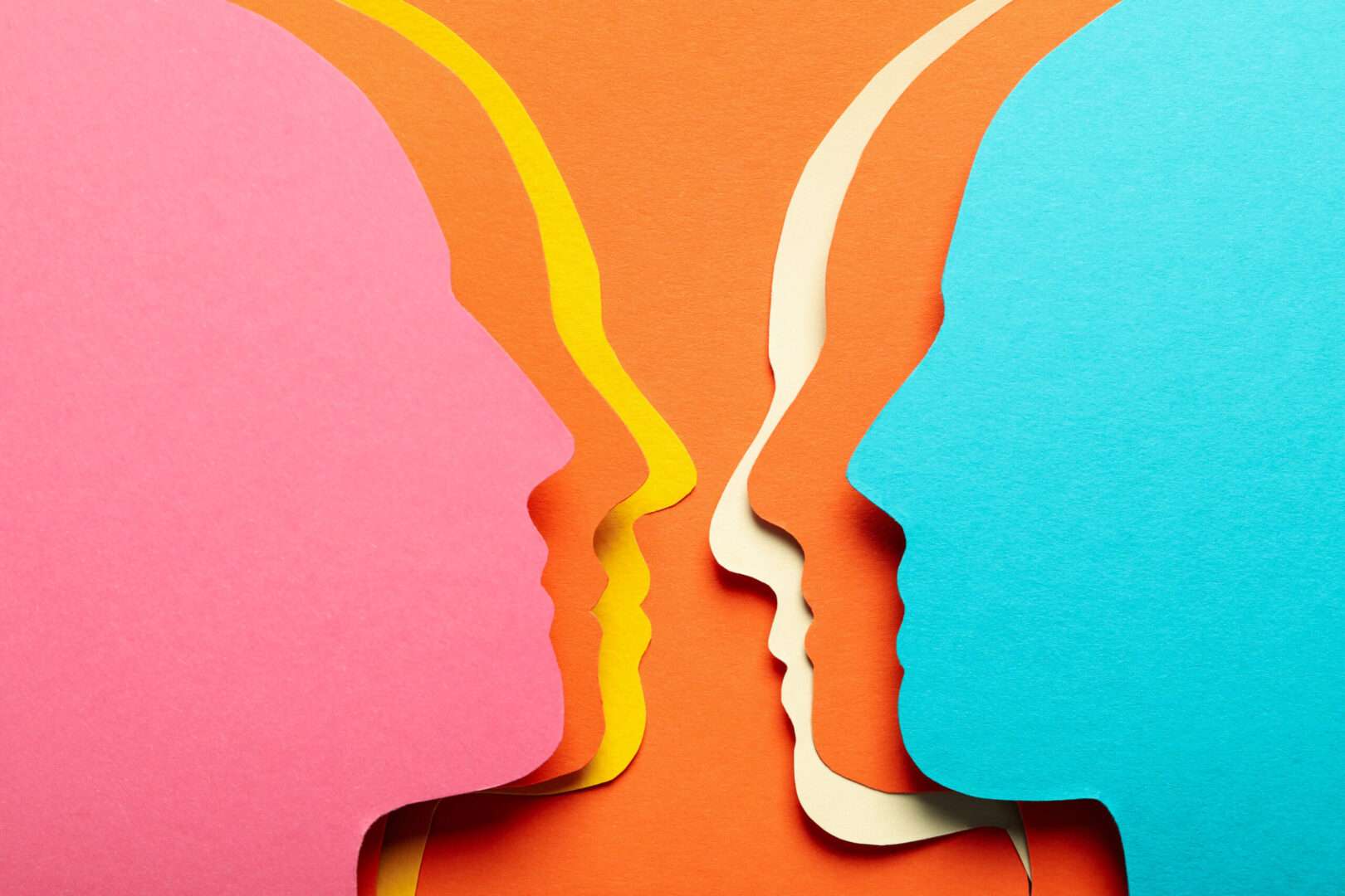 Two colorful paper-cut human face silhouettes facing each other in pink, yellow, orange, and teal, representing trademark confusion, brand identity conflicts, and the importance of trademark protection for Los Angeles businesses