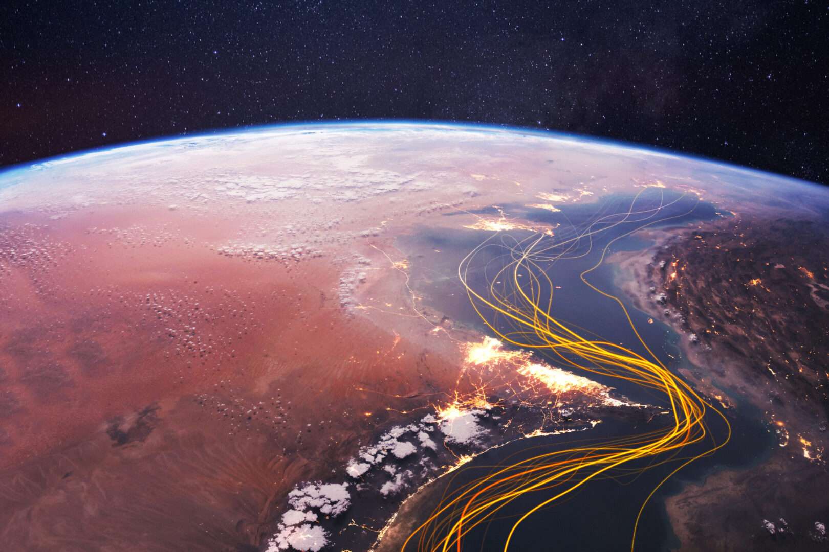 A satellite aerial view of the Strait of Hormuz, the narrow waterway between Iran and Oman that controls roughly 20% of the world's daily oil supply and directly impacts gas prices for small businesses across the United States.