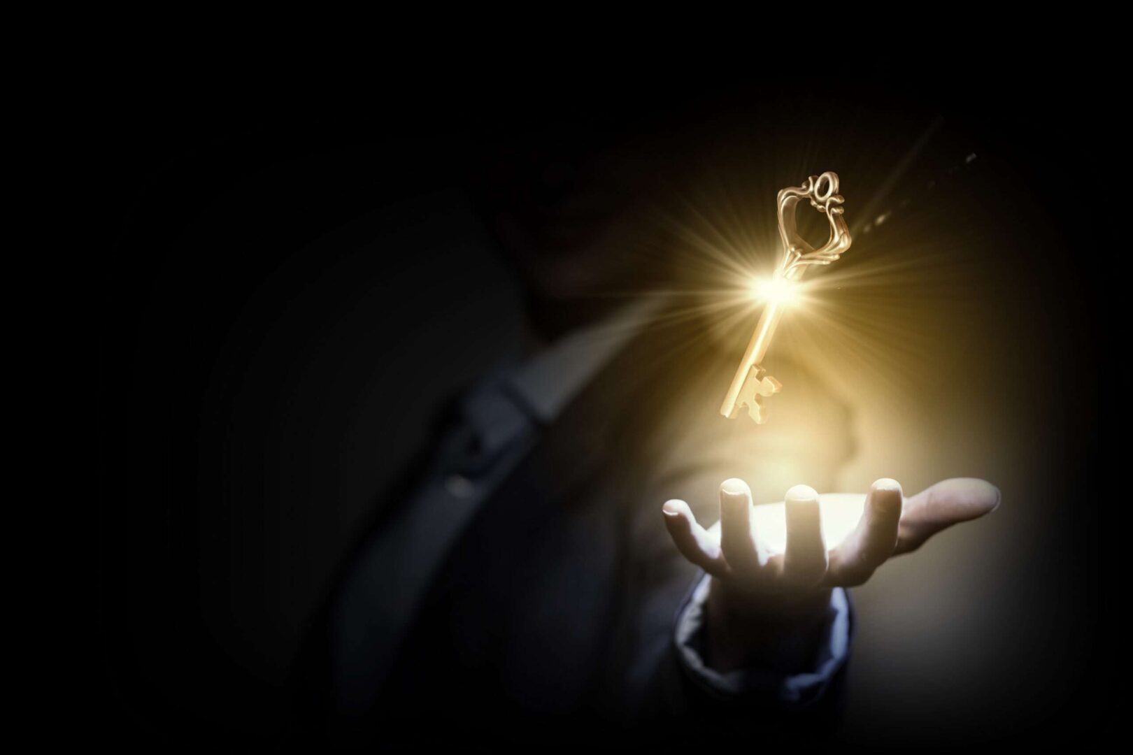 A business person holding out an open hand as a glowing golden key floats above it, symbolizing how the right business lawyer unlocks growth and success for Inland Empire companies.