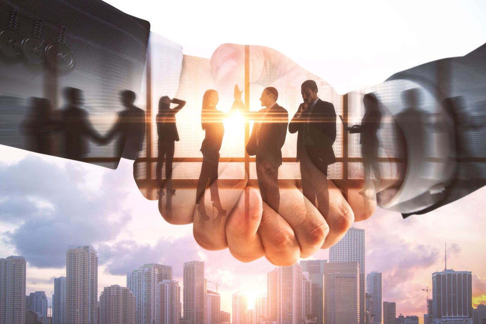 A double-exposure image of a business handshake overlaid with silhouettes of professionals and a city skyline at sunset, representing corporate mergers and the antitrust law that governs them.