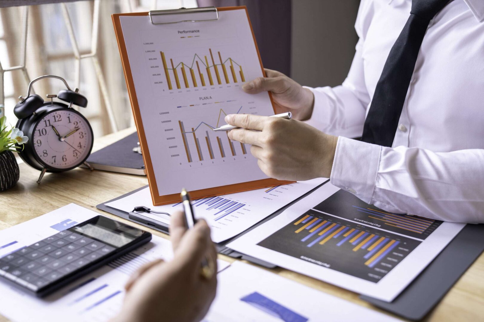 Financial analyst reviewing performance charts and revenue graphs during a quality of earnings analysis before a business acquisition