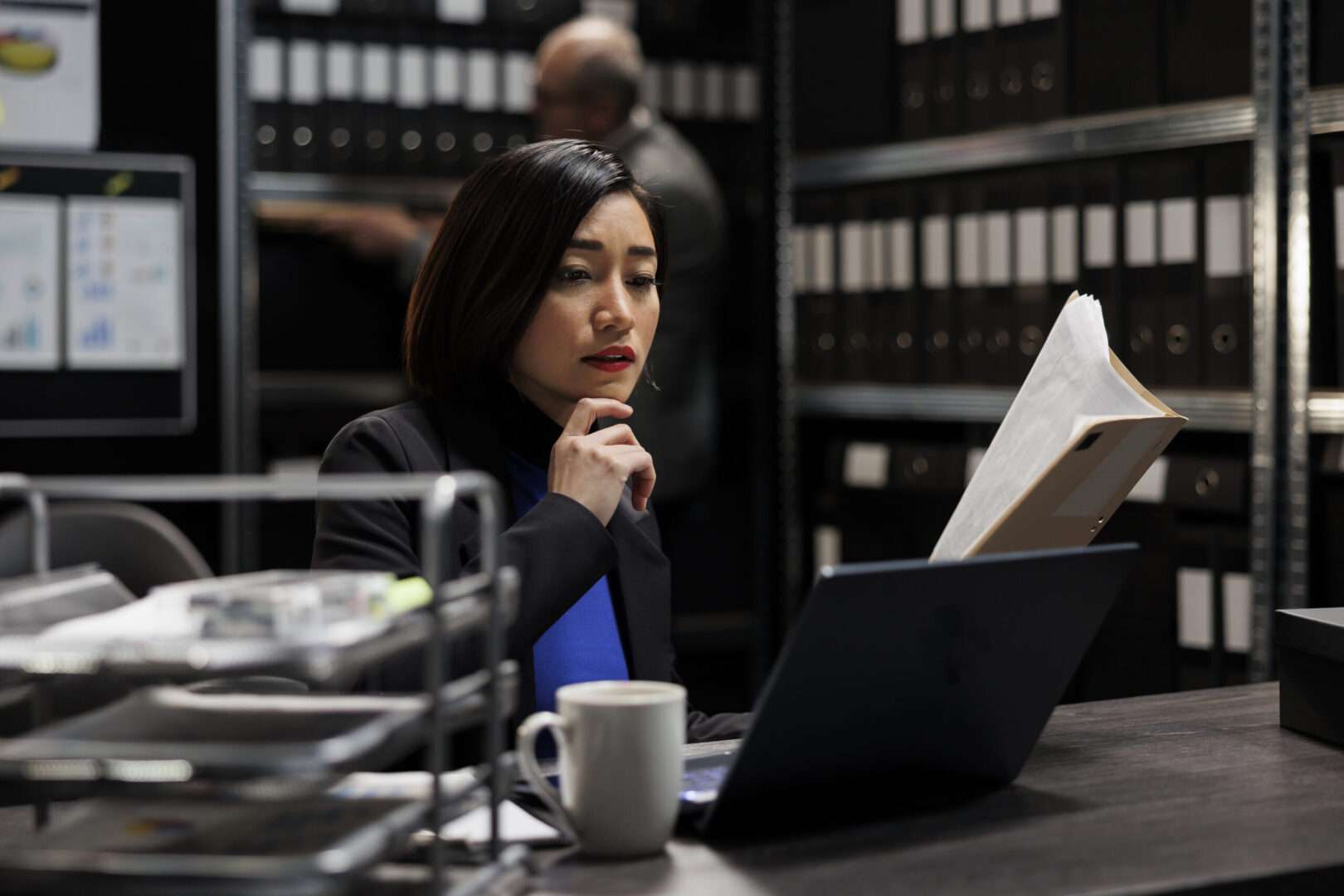 Business owner reviewing documents at her laptop while researching how to choose a business lawyer in Los Angeles