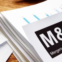 Stack of M&A documents with charts representing merger and acquisition data