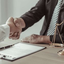 Two professionals shaking hands over a legal contract, symbolizing resolution of trademark concerns with legal support in Los Angeles.